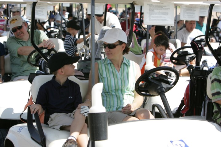 Parent and child golfers sitting in golf cart